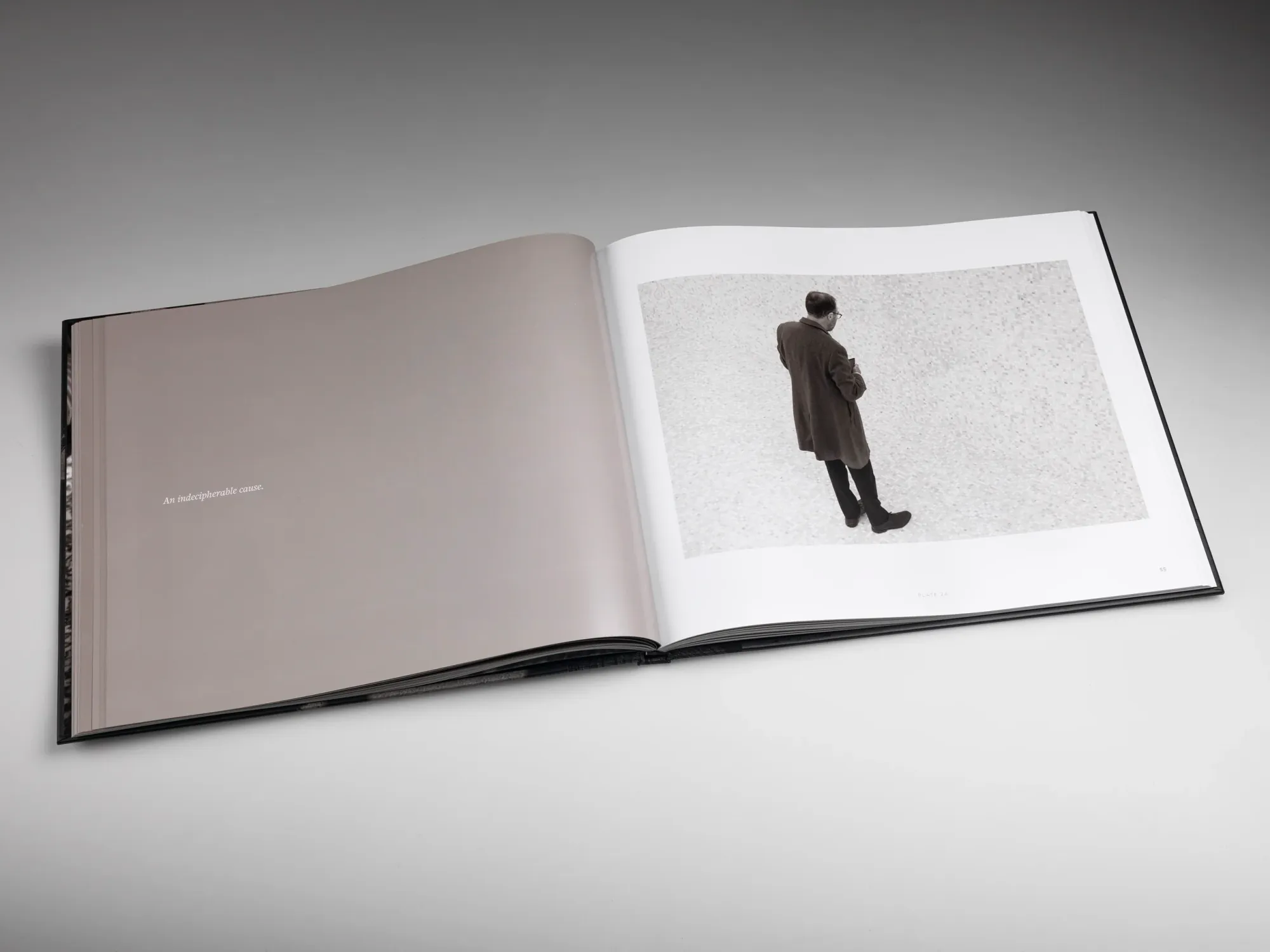 Interior of a book with illegible text on the left and an image of a solitary man on the right