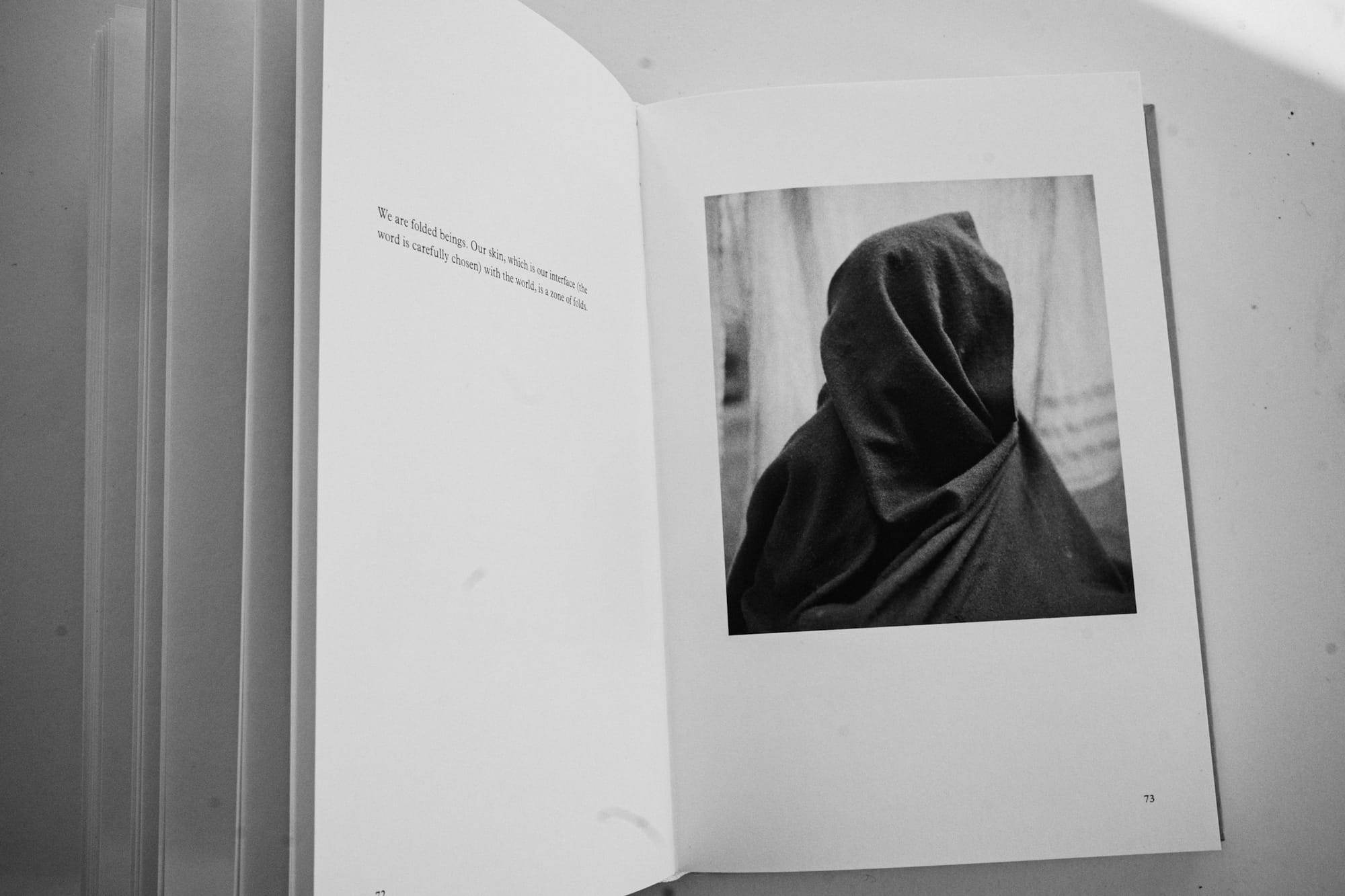 A page from the Human Archipelago book with illegible text on the left and image of a person obscured in cloth