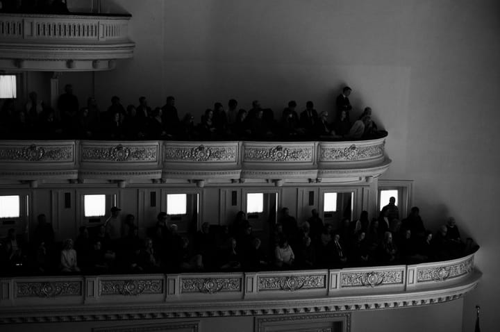 two ornate rows of seats at Carnegie Hall with audience members viewing the stage below